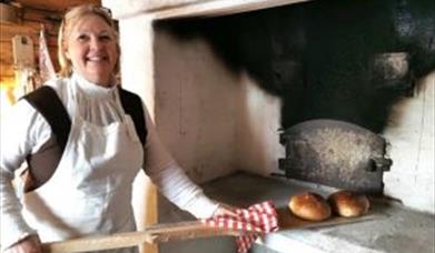 Kjersti Horgen baker i den gamle bakerovnen. Foto: Anne Gallefos Wollertsen