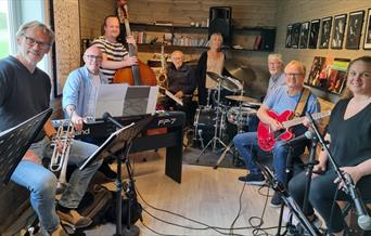 Jensens jazzband består av fra venstre Trond Vetterstad(trompet), Børre Jensen(piano), Robert Opsahl(bass), Nils Petter Hobbelstad(sax), Ann Karin Nilsen(vokal), Egil Fritzøe(trommer), Halvard Foss(gitar) og Heidi Medalen Westbye(vokal).